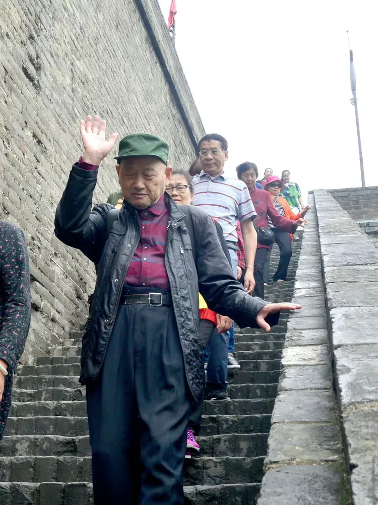 七旬老太西安城墙演绎军人风采引热议 七旬老太西安城墙演绎军人风采引热议